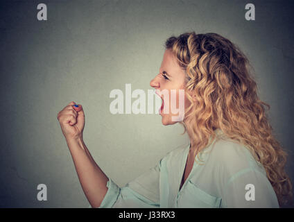 Angry woman screaming with fist up in air Stock Photo