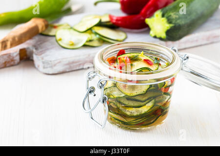 Marinated zucchini salad canned in glass jar Stock Photo