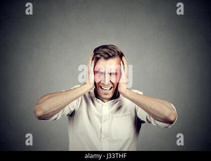 man with headache isolated on gray wall background Stock Photo