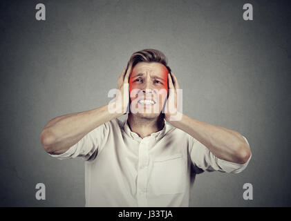 man with headache isolated on gray wall background Stock Photo