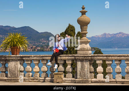 Tourist taking a selfie at Isola Bella gardens at Isola Bella, Lake Maggiore, Italy in April Stock Photo