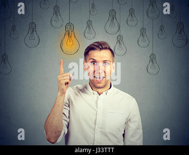 happy young man pointing at light bulb has a solution Stock Photo