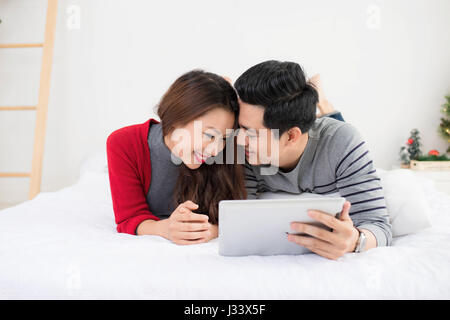 Asian couple using digital tablet at home Stock Photo