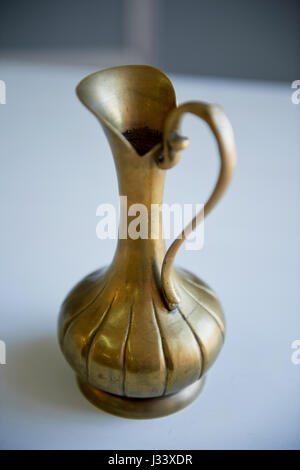 Old bronze pitcher on a light background. Retro Oriental style Stock Photo
