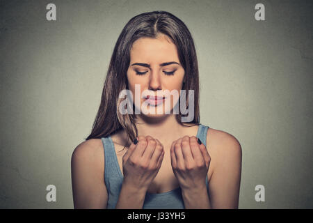 Worried woman looking at hands fingers nails obsessing about cleanliness isolated on grey background. Negative human emotion facial expression feeling Stock Photo