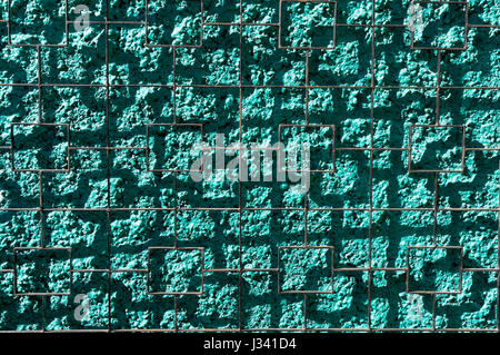 Wire grid casting square shadows on a bright green stucco wall abstract background Stock Photo