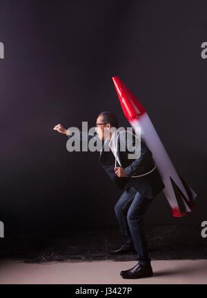 crazy man carrying rocket missile weapon on back actiing with mad of powerful Stock Photo
