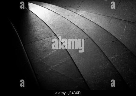 Granite stairs in black and white. Curved with light shining on them. Stock Photo