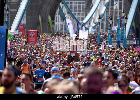 Gregory Bryant running as a bottle of London Pride among the mass of runners in the 2017 London Marathon near Tower Bridge Stock Photo