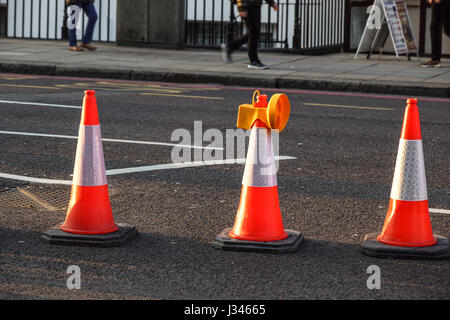 traffic cone, with white on gray asphalt, at roadwork Stock Photo