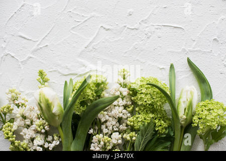 White textured background with fresh spring flowers, design ready frame with copy space Stock Photo