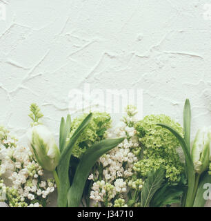 White textured background with fresh spring flowers, design ready frame with copy space Stock Photo