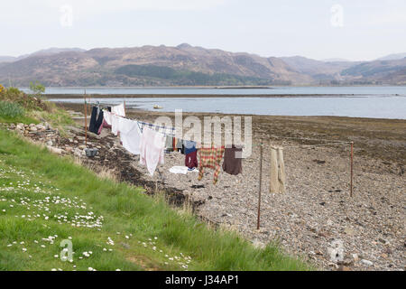 clothes drying on washing line on the beach in Lochcarron in the Scottish Highlands Stock Photo