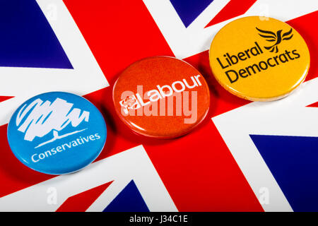 LONDON, UK - MAY 2ND 2017: Conservatives, Labour and Liberal Democrat pin badges over the UK flag, symbolizing the political battle for the General El Stock Photo