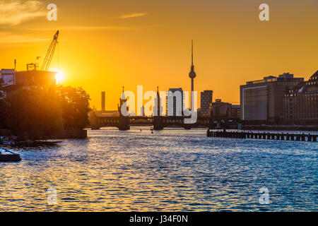 Beautiful view of Berlin skyline with famous TV tower and Oberbaum Bridge at river Spree in golden evening light at sunset, Berlin Friedrichshain-Kreu Stock Photo