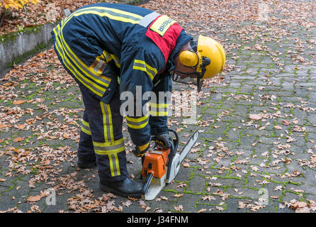 German Fireman in action outdoors with chainsaw Stock Photo