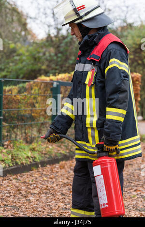 German firefighter in a action with a fire extinguisher Stock Photo