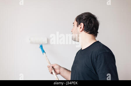 Man paints a wall in white Stock Photo