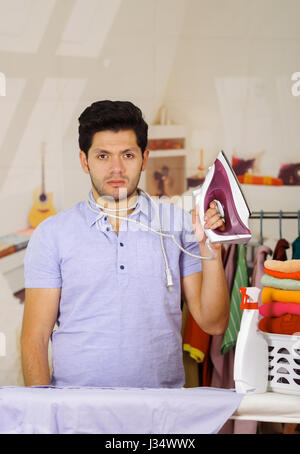 Handsome young Man worried because he has an iron cable around his neck Stock Photo