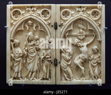 Madonna and child between Saint John the Evangelist and Saint John the Baptist and the Crucifixion. Ivory diptych dated from ca. 1330 on display in the Musee des Beaux-Arts de Dijon (Museum of Fine Arts) in Dijon, Burgundy, France. Stock Photo