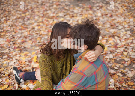 Happy young couple kissing in a park Stock Photo
