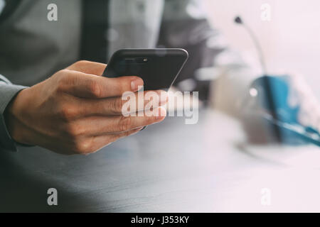 businessman using VOIP headset with mobile phone and concept communication call center on wooden desk Stock Photo