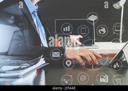 businessman using digital tablet and laptop computer and document in modern office with virtual interface graphic icons network diagram Stock Photo