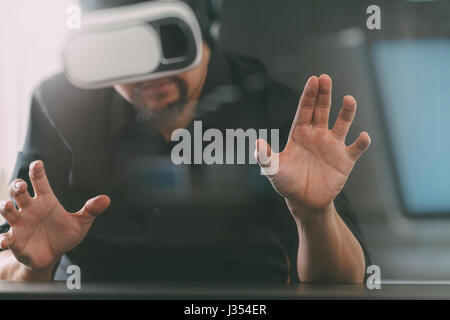 businessman wearing virtual reality goggles in modern office with Smartphone using with VR headset Stock Photo