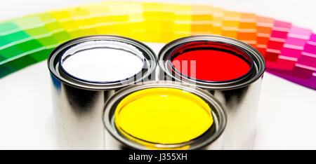 Three paint cans and paint color samples, Colorful paint tins Stock Photo