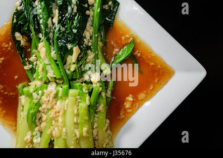 Chinese Broccoli with Oyster Sauce in black background Stock Photo