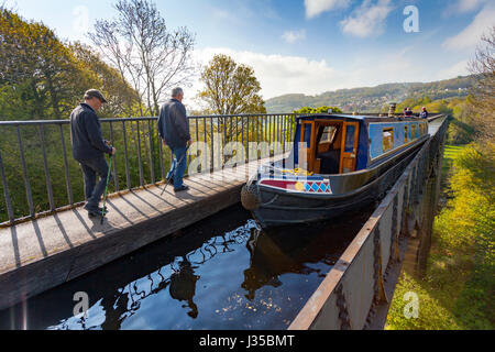 A canal barge and walkers travelling over the Unesco World Heritage Site of Pontcysllte Aqueduct in North Wales on a summers morning Stock Photo