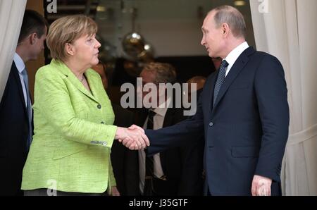 Russian President Vladimir Putin thanks German Chancellor Angela Merkel following bilateral discussions at his Black Sea residence May 2, 2017 in Sochi, Russia. Merkel is in the Russian resort town to discuss the conflicts in Syria and Ukraine. Stock Photo