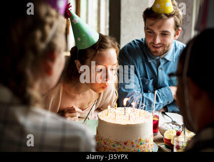 Woman Blowing Candles on Cake on Her Birthday Party Celebration Stock Photo