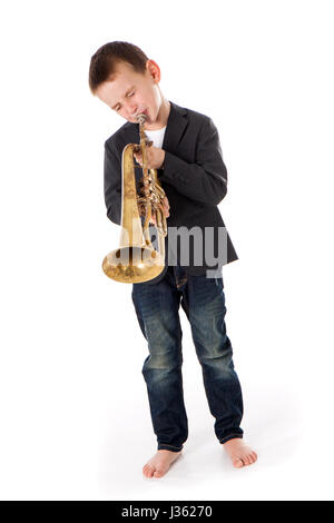 young boy blowing into a trumpet against white background Stock Photo