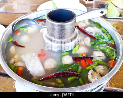 Serving of spicy fish soup Thai style in a hot pot Stock Photo