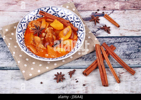 Thai massaman curry paste recipe served in Thai pattern bowl and herbs on wood Stock Photo