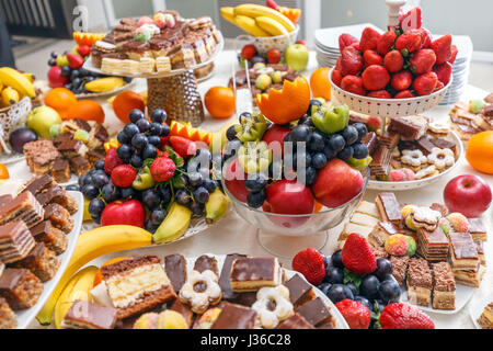 Wedding table full of fruits and berries and an assortment of sweets Stock Photo