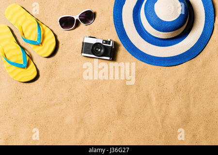 Pair of flip flop sandals, sunglasses, hat and camera. Stock Photo