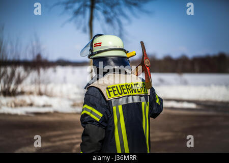 Firefighter in action outdoor with a axe - HDR Stock Photo