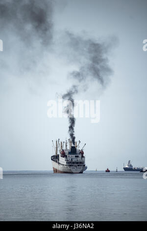 Black smoke from funnel of Russian trawler as ship leaves port. Stock Photo
