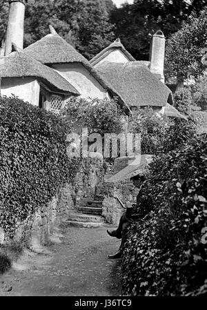 Cottage and Steps, Selworthy, Exmoor, taken in September 1907. Note the artist sitting on the front right of the picture. Stock Photo