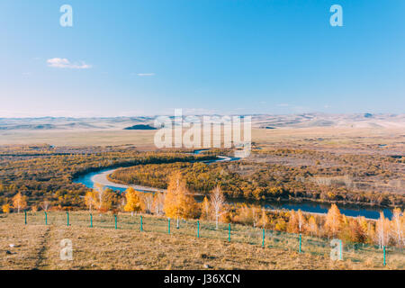 on a moutain of Inner Mongolia Hulun Buir River Genhe Wetland in Eergu'Na,known as 'Asia's first wetlands.', in Autumn with yellow trees and blue sky Stock Photo