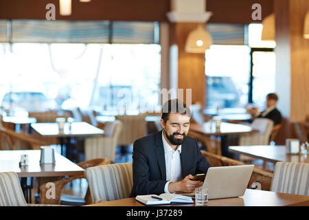 Cheerful Businessman Working in Cafe Stock Photo