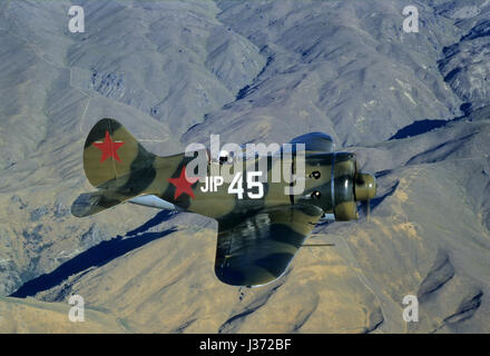 Pilot is waving and flying a rare Soviet fighterplane from WW II Polikarpov I-16 Rata flying over The Southern Alps in New Zealand Stock Photo