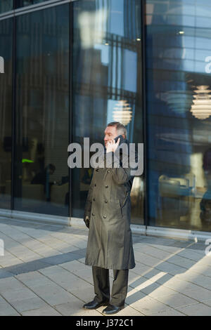 Mature Businessman Using Smartphone Outdoors Stock Photo