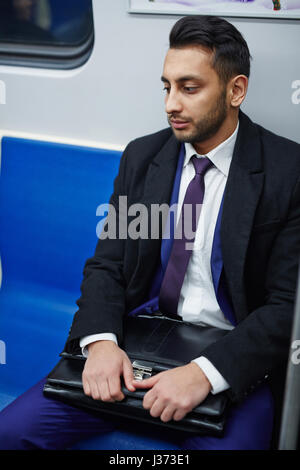 Tired Middle-Eastern Businessman on Subway train Stock Photo