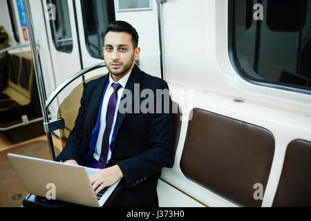 Businessman Working with Laptop in Subway Stock Photo