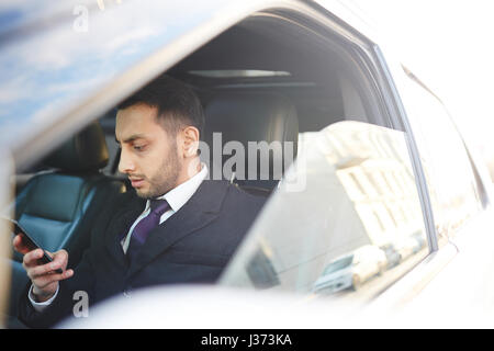 Successful Businessman Using Smartphone inside car Stock Photo