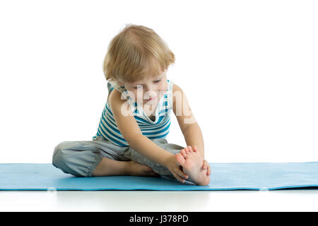 Child practicing yoga, stretching in exercise wearing sportswear. Kid isolated over white background Stock Photo