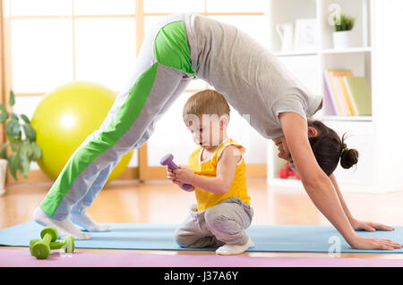 mother doing yoga or fitness exercises with baby Stock Photo